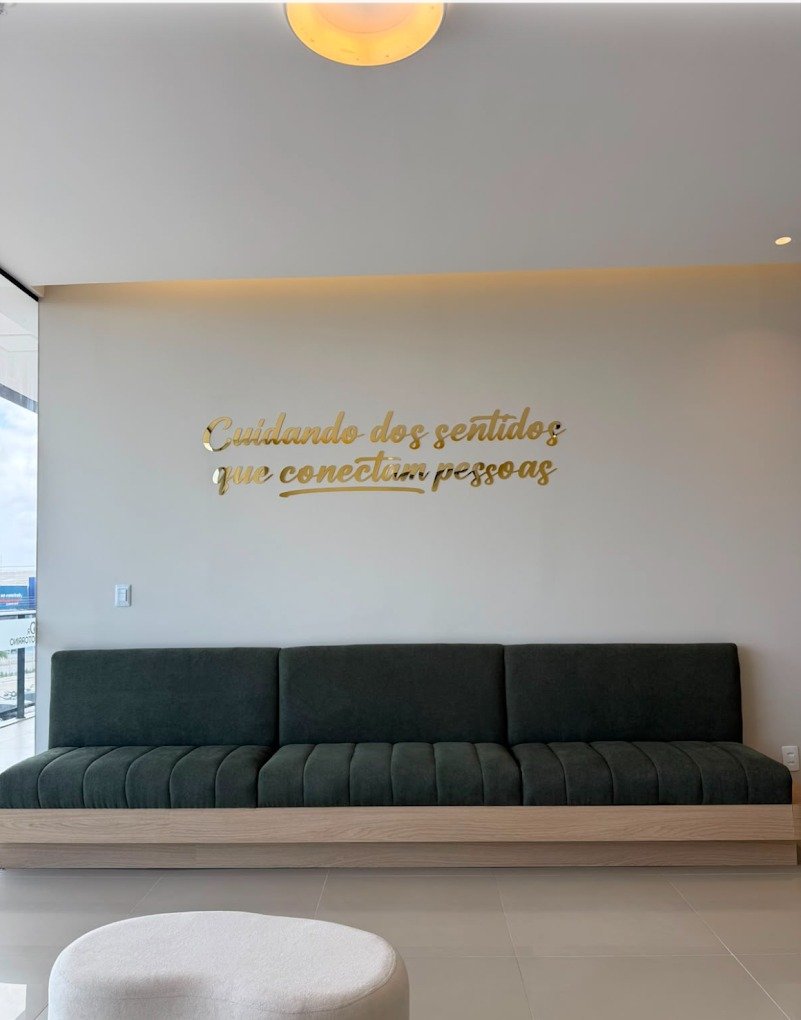Sofá da sala de espera sob a frase da clínica sobre cuidar dos sentidos